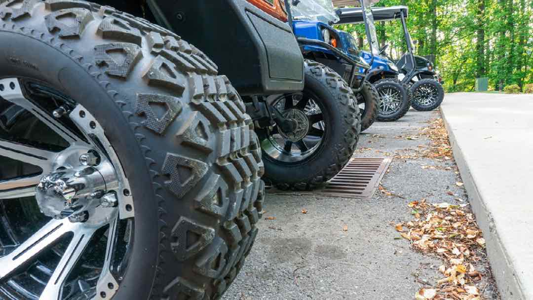 How do larger wheels contribute to a smoother golf cart ride